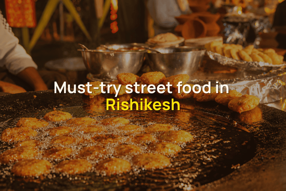 Street-style aloo tikki being fried on a large griddle at a bustling food stall in Rishikesh